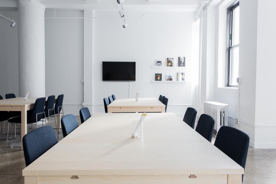 A meeting room with a long table and chairs